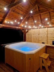 uma grande banheira de hidromassagem num quarto de madeira com luzes em W Sosnach em Tokarnia