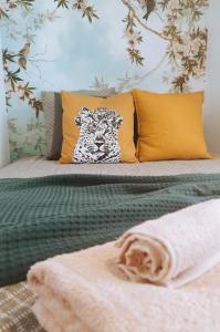 uma cama com lençóis e almofadas amarelos e verdes em Nid paisible à 10 min de Disney em Bussy-Saint-Georges