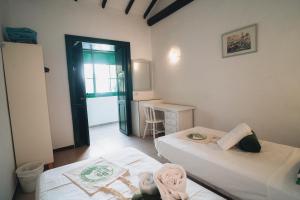 Habitación pequeña con 2 camas y escritorio. en Cactus Coliving and Coworking, en San Sebastián de la Gomera