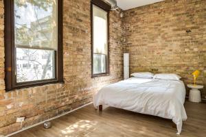 Un dormitorio con una pared de ladrillo y una cama en Beautifully Remodeled Flat Downtown #3N en Chicago