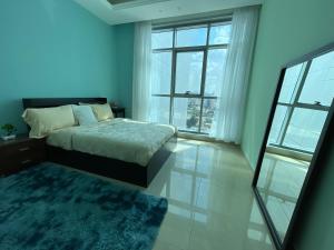 a bedroom with a bed and a large window at Luxurious Sea View - Beach Front in Ajman 