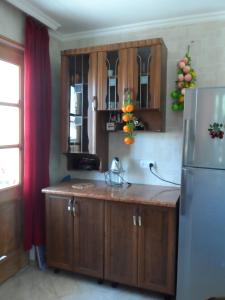 Una cocina con gabinetes de madera y refrigerador. en California Guest House, en Gori