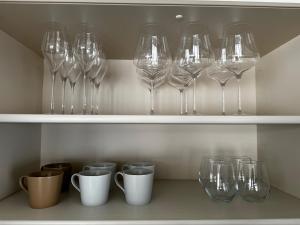 une rangée de verres à vin assis sur une étagère dans l'établissement Mountain Villa ニセコ, à Kutchan