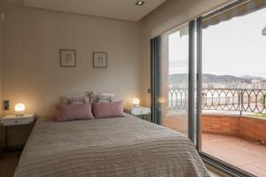 a bedroom with a large bed and a balcony at Miraconcha 47 in Donostia-San Sebastián +70 photos
