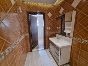 La salle de bains est pourvue d'un lavabo et d'un miroir. dans l'établissement شقق الراحه, à Al Muzāḩimīyah