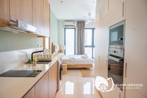 a kitchen with a sink and a living room at HighPark Suites in Petaling Jaya, Kelana Jaya by Plush in Kampong Baharu Sungai Way