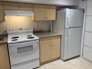 a kitchen with a white stove and a refrigerator at Cosy comfortable basement apartment. in Toronto