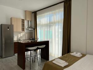 a kitchen with a bed and a kitchen with a counter at Apart Hotel Perla Resort Lalez Durres in Durrës