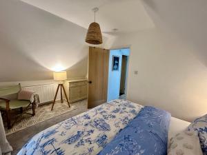 a bedroom with a bed and a desk and a lamp at The Coach House - Bournemouth in Bournemouth