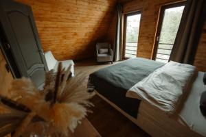 Twin Cabins / Cabanele Gemene في سوسيفا: غرفة نوم مع سرير في غرفة مع نوافذ
