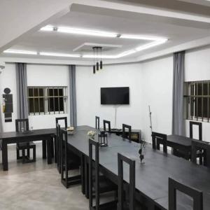 a dining room with a table and chairs and a tv at RESIDENCE MGA HOTEL in Ouidah