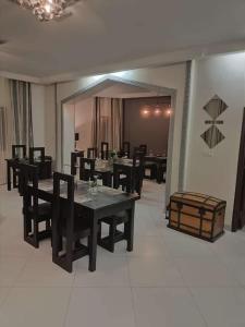 a dining room with black tables and chairs and a room with at RESIDENCE MGA HOTEL in Ouidah