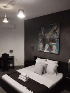 sypialnia z łóżkiem z obrazem na ścianie w obiekcie RESIDENCE MGA HOTEL w mieście Ouidah