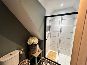a bathroom with a toilet and a glass shower at The Coach House - Bournemouth in Bournemouth