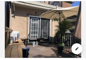 a patio with an umbrella on a balcony at Cosy comfortable basement apartment. in Toronto