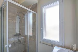 een badkamer met een douche, een wastafel en een raam bij Le Valois / Vue Sur Château D'Amboise in Amboise