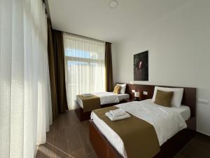 pokój hotelowy z 2 łóżkami i oknem w obiekcie Apart Hotel Perla Resort Lalez Durres w Durrës