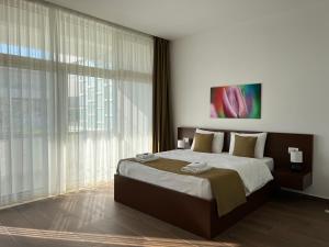 a bedroom with a large bed and a large window at Apart Hotel Perla Resort Lalez Durres in Durrës