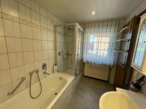 uma casa de banho com uma banheira, um chuveiro e um lavatório. em Ferienwohnung Kiebitzheide em Beelen