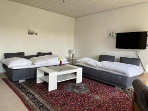 uma sala de estar com 2 camas e uma mesa de centro em Ferienwohnung Kiebitzheide em Beelen