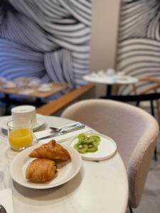 佩羅斯－吉雷克的住宿－Hôtel Les Costans, The Originals Relais，一张桌子,上面放着两盘食物和一杯橙汁