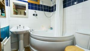 une salle de bain avec une baignoire, un lavabo et des toilettes dans l'établissement Capel Bach, à Llanystumdwy 42 autres photos