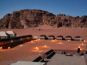 a desert with a mountain in the background at Wadi Rum Candles Camp in Wadi Rum