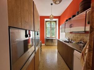 una cocina con armarios de madera y una pared de color naranja en Lötschberg, en Kippel