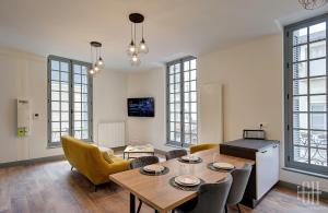 - un salon avec une table et des chaises dans l'établissement Le Racine / Colbert - Bords De Loire, à Tours