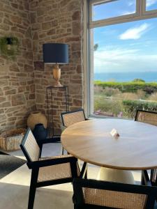 comedor con mesa, sillas y ventana en Hôtel Les Costans, The Originals Relais en Perros-Guirec