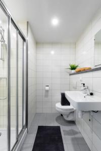 een witte badkamer met een wastafel en een toilet bij Apartments Skyreach-WohnZimmer in Essen