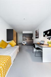 a bedroom with a bed and a desk with a laptop at Apartments Skyreach in Essen
