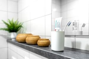 Baño con estante con cepillo de dientes y cestas en Apartments Skyreach-WohnZimmer, en Essen