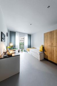 a large living room with a bed and a table at Apartments Skyreach in Essen