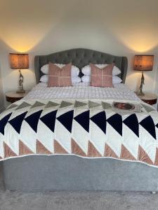 Una cama grande con almohadas rosas encima. en Luxury in the Lake District en Dockray