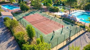 eine Aussicht auf einen Tennisplatz mit zwei Personen in der Unterkunft Mobil Home XXL 4 chambres - Camping Tarn - Domaine du Koukano in Maurens-Scopont