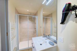 La salle de bains blanche est pourvue d'une douche et d'un lavabo. dans l'établissement Le Vinci / Proche Château D'Amboise, à Amboise