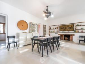 a dining room with a table and chairs and a fireplace at Seaside Pineta Retreat in Pula