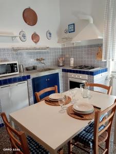 a kitchen with a table with plates and wine glasses at Appartamento Billa in Deiva Marina