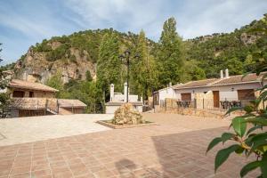 a courtyard with a monument in front of a mountain at Apartamentos 7 puentes sierra Cazorla Casa Pino in Burunchel