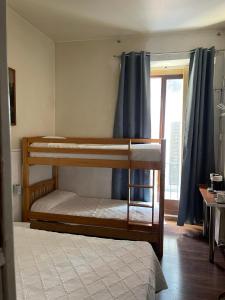 2 łóżka piętrowe w pokoju z oknem w obiekcie HOSTAL DANIEL w Madrycie