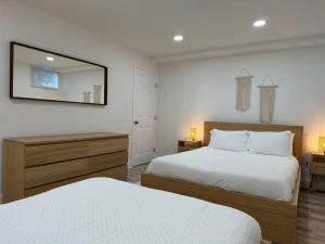 a bedroom with two beds and a mirror on the wall at Garden's Grace: Whispers in Silver Spring