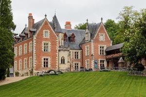 un grand bâtiment en briques avec une grande pelouse devant lui dans l'établissement Le Vinci / Proche Château D'Amboise, à Amboise