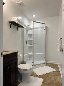a white bathroom with a shower and a toilet at Garden's Grace: Whispers in Silver Spring