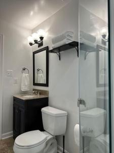 a bathroom with a toilet and a glass shower at Garden's Grace: Whispers in Silver Spring