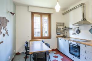 Bartoli Holidays, Bologna by Short Holidays في بولونيا: مطبخ مع طاولة وكراسي في غرفة