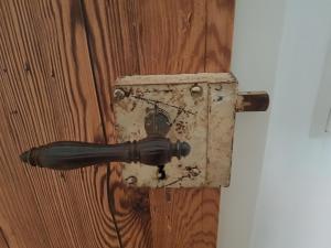 a metal latch on a wooden wall with a box at Ehemalige Schmiede -Dormitorium- in Ochsenhausen
