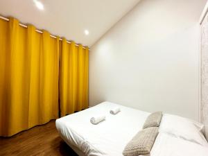 a bedroom with yellow curtains and a bed at Le Petit Landais - Chaleureux - Clim - Central in Mont-de-Marsan