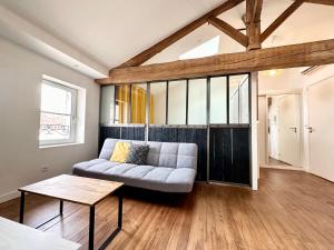 a living room with a couch and a table at LE PETIT LANDAIS - Chaleureux in Mont-de-Marsan