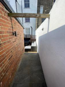 an alley with a brick wall and a building at Coastal Comfort, Hot Tub Lodge in Margate